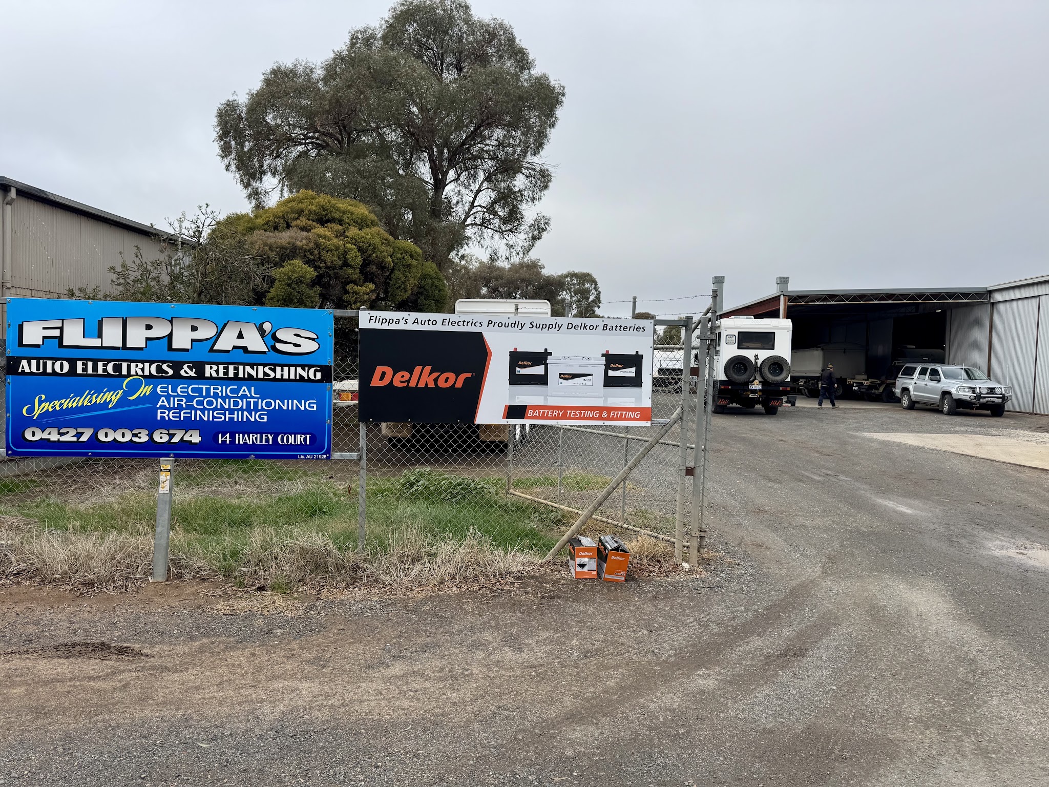 Flippa's Auto Electrics & Refinishing sign and Delkor battery banner at the gate on Harley Court, Finley