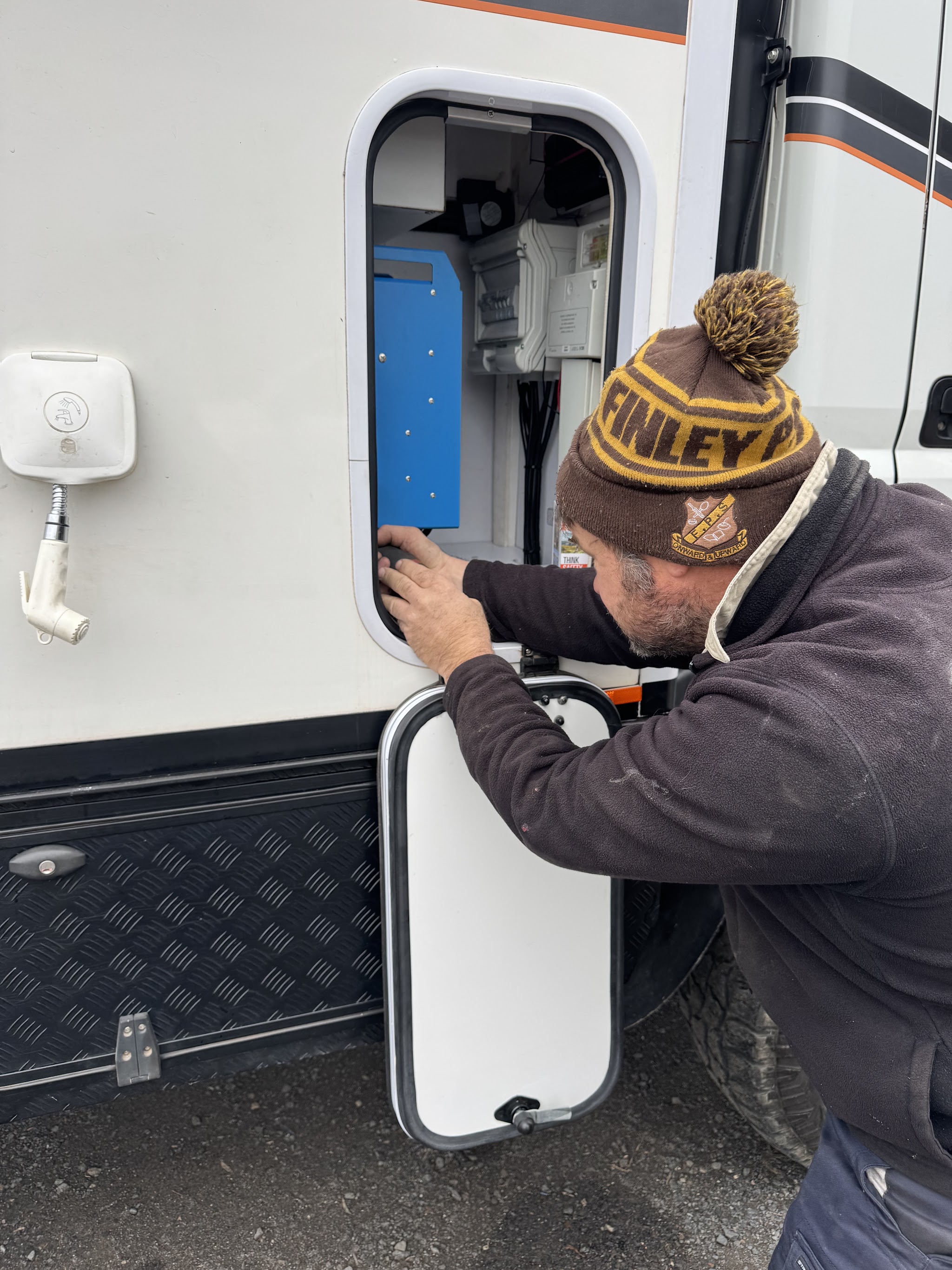 Working on the electrics inside a caravan's service hatch